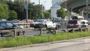 Coche de patrulla de policía circulando por una carretera con tráfico intenso en verano.