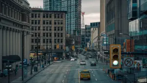 Tráfico urbano en una avenida transitada rodeada de edificios altos y modernos.