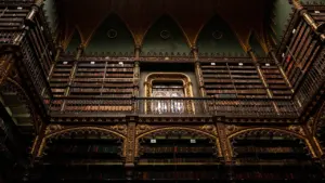 Imponente biblioteca antigua con estanterías de madera ornamentadas y una atmósfera gótica clásica.