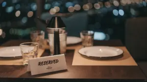Mesa reservada en restaurante elegante con luces urbanas desenfocadas al fondo