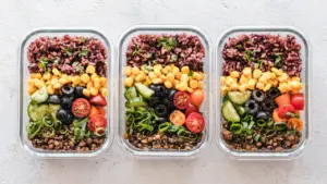Tres recipientes de vidrio con comida saludable preparada para toda la semana.