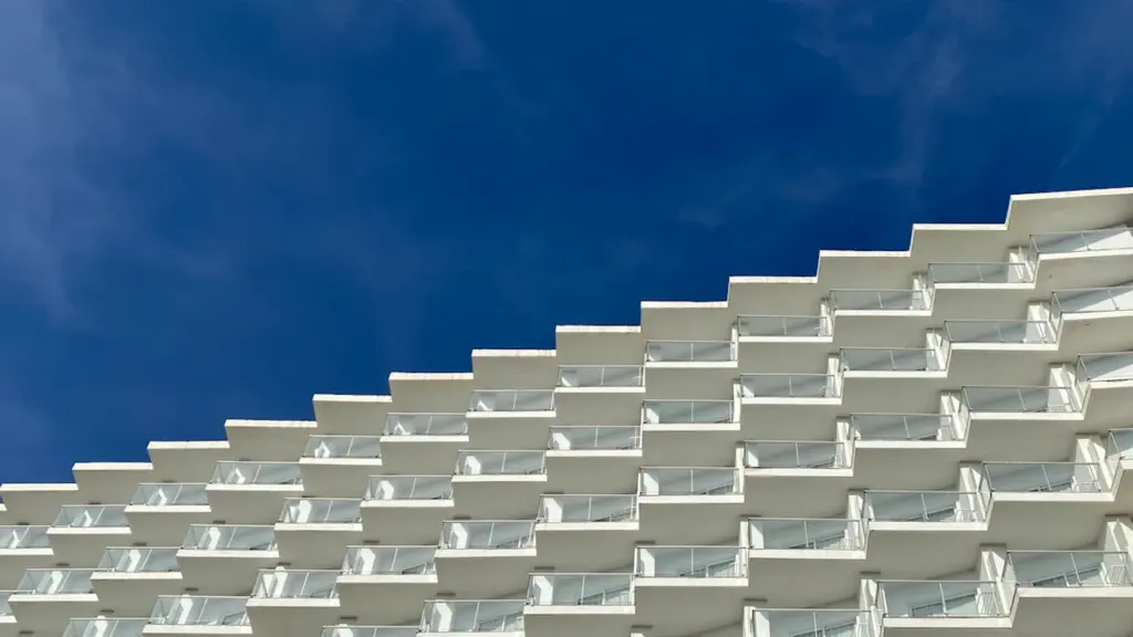 Fachada moderna de hotel con balcones bajo un cielo azul en Torremolinos, Málaga.