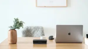 Ordenador portátil sobre una mesa de madera clara en una oficina moderna y luminosa.