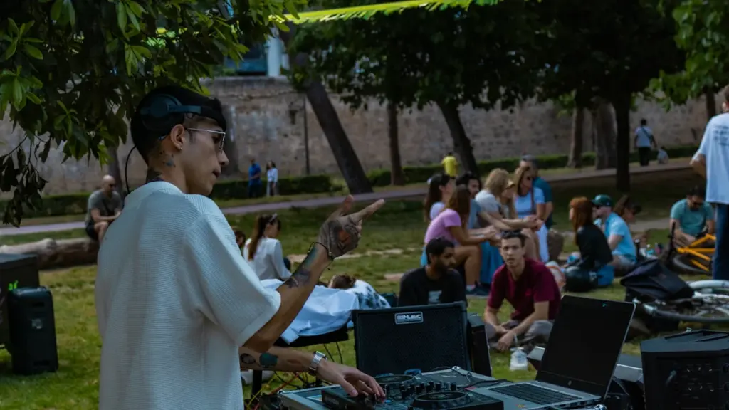 DJ poniendo música en un evento cultural al aire libre en un parque.