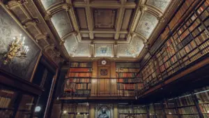 Vista interior de una elegante biblioteca histórica con estanterías llenas de libros antiguos.