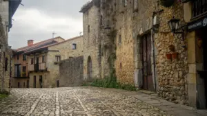 Calle empedrada con edificios de piedra rústica en el casco histórico de una ciudad.