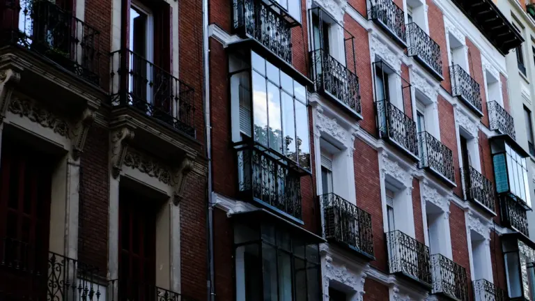 Fachada de edificio residencial con balcones típicos en el centro de Madrid, España.