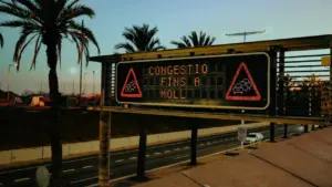 Panel informativo de tráfico indicando congestión en una carretera urbana española.